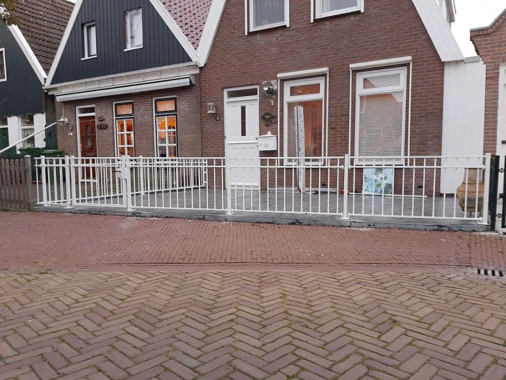 Sierhekwerk met spijlen als erfafscheiding bij een woning
