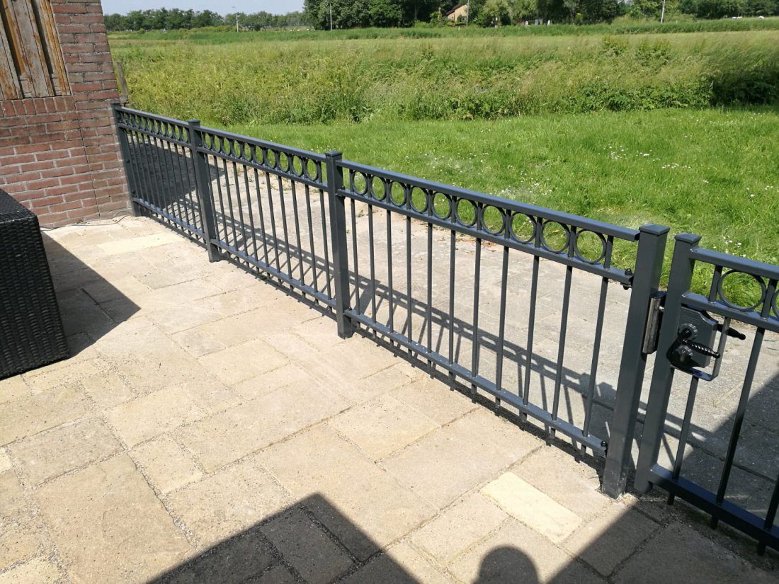 Zwart sierhekwerk rond een voortuin dat goed onderhouden is