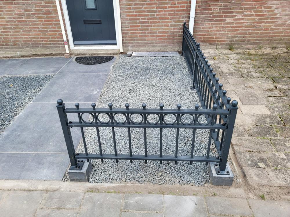 Sierhekwerk met voetplaten in RAL 7016 op een muurtje