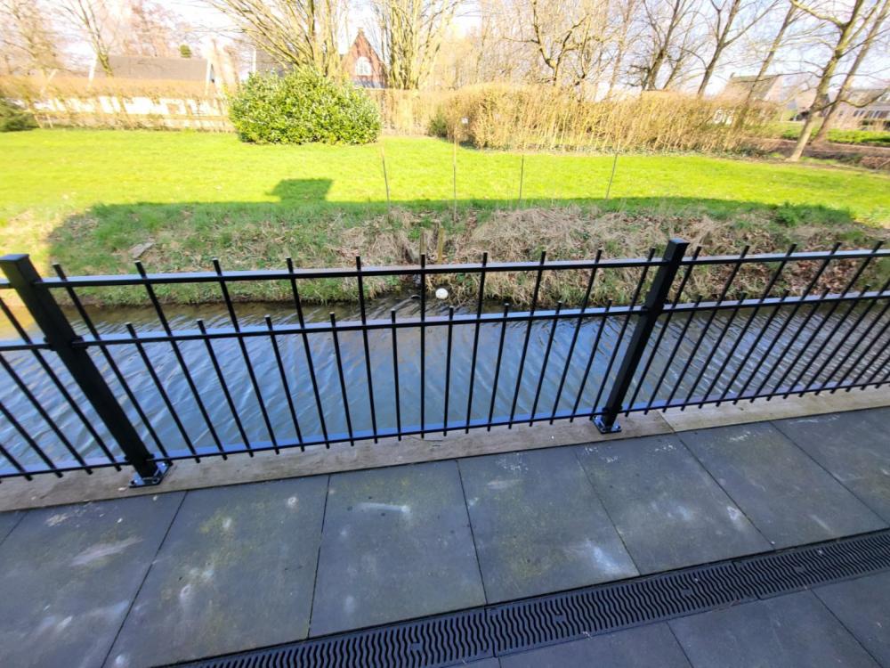Sierhekwerk gemonteerd op voetplaten op een verharde ondergrond