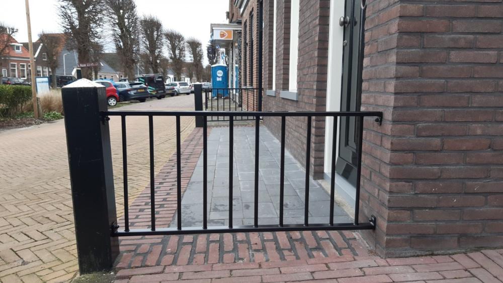 Sierhekwerk tussen twee muren als afscheiding op erfhoogte