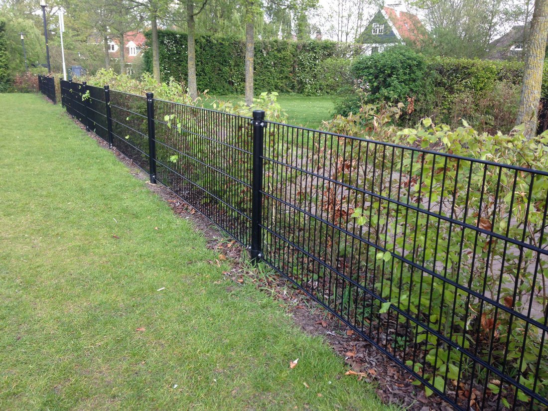 Dubbelstaafmat hekwerk langs een glooiend grasveld
