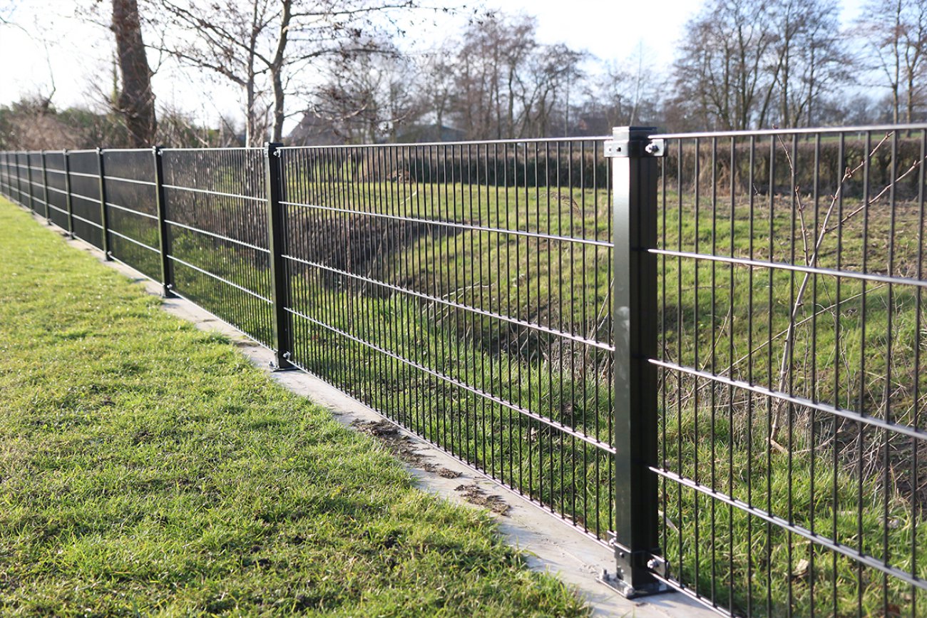 Dubbelstaafmat hekwerk met een betonband langs een talud